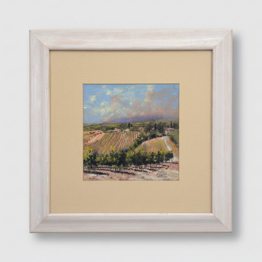 Framed painting of a landscape with trees and mountains on a textured wall.
