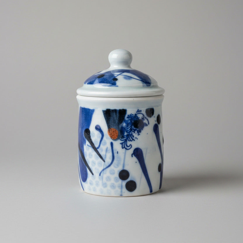Ceramic jar with blue and white floral design on a textured white background