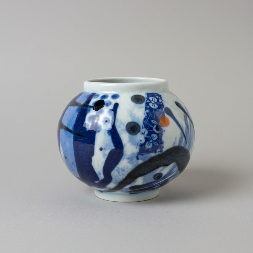 Decorative ceramic jar with blue and white pattern on a white wall