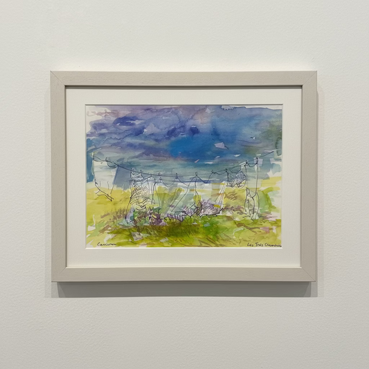 A framed watercolor landscape painting of power lines and grassy fields, displayed on a white pedestal against a textured beige wall.