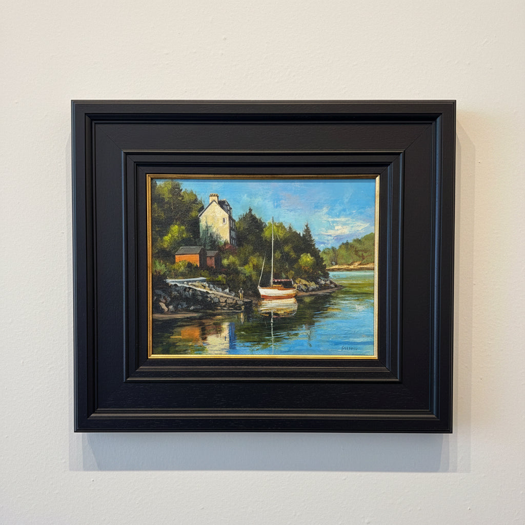 Framed painting of a coastal scene with a house and boat on a lake.