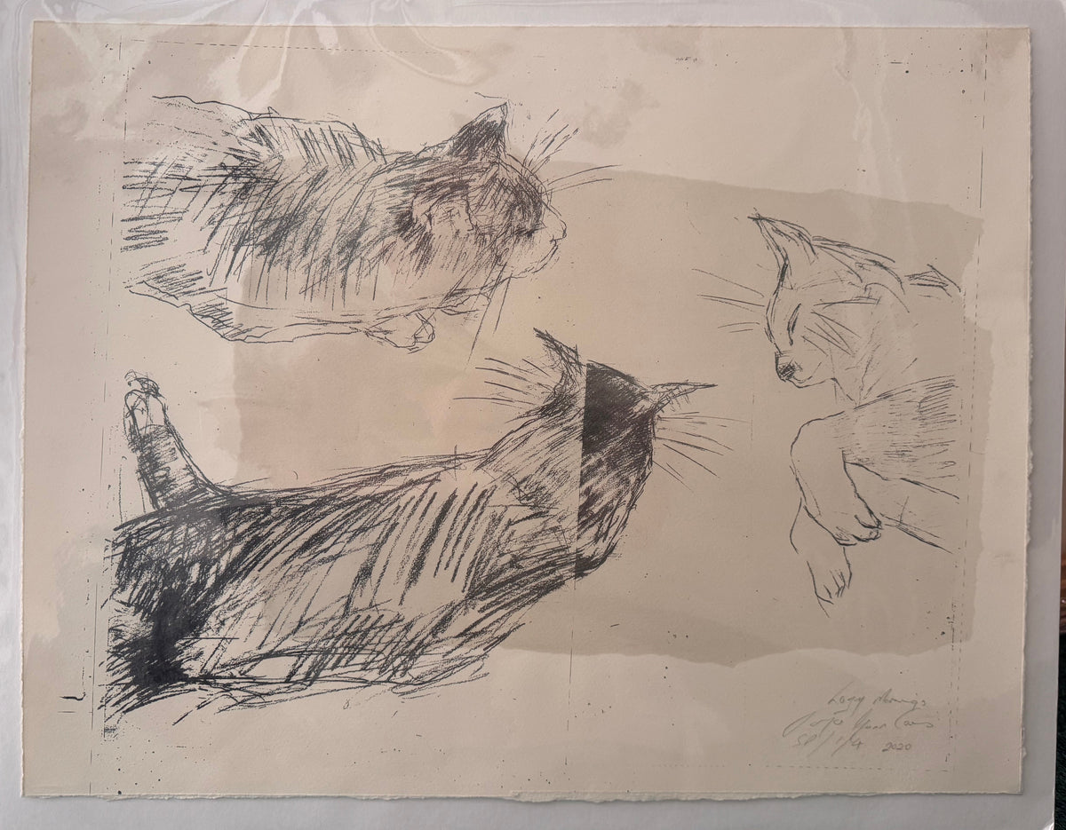 A framed monochrome sketch of three cats on aged paper, photographed indoors on a green carpeted floor.