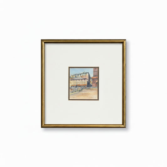 Framed artwork of a cityscape on a textured wall