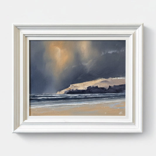 a painting of a coastal scene showing cliffs and a turbulent sky. In a white wooden frame