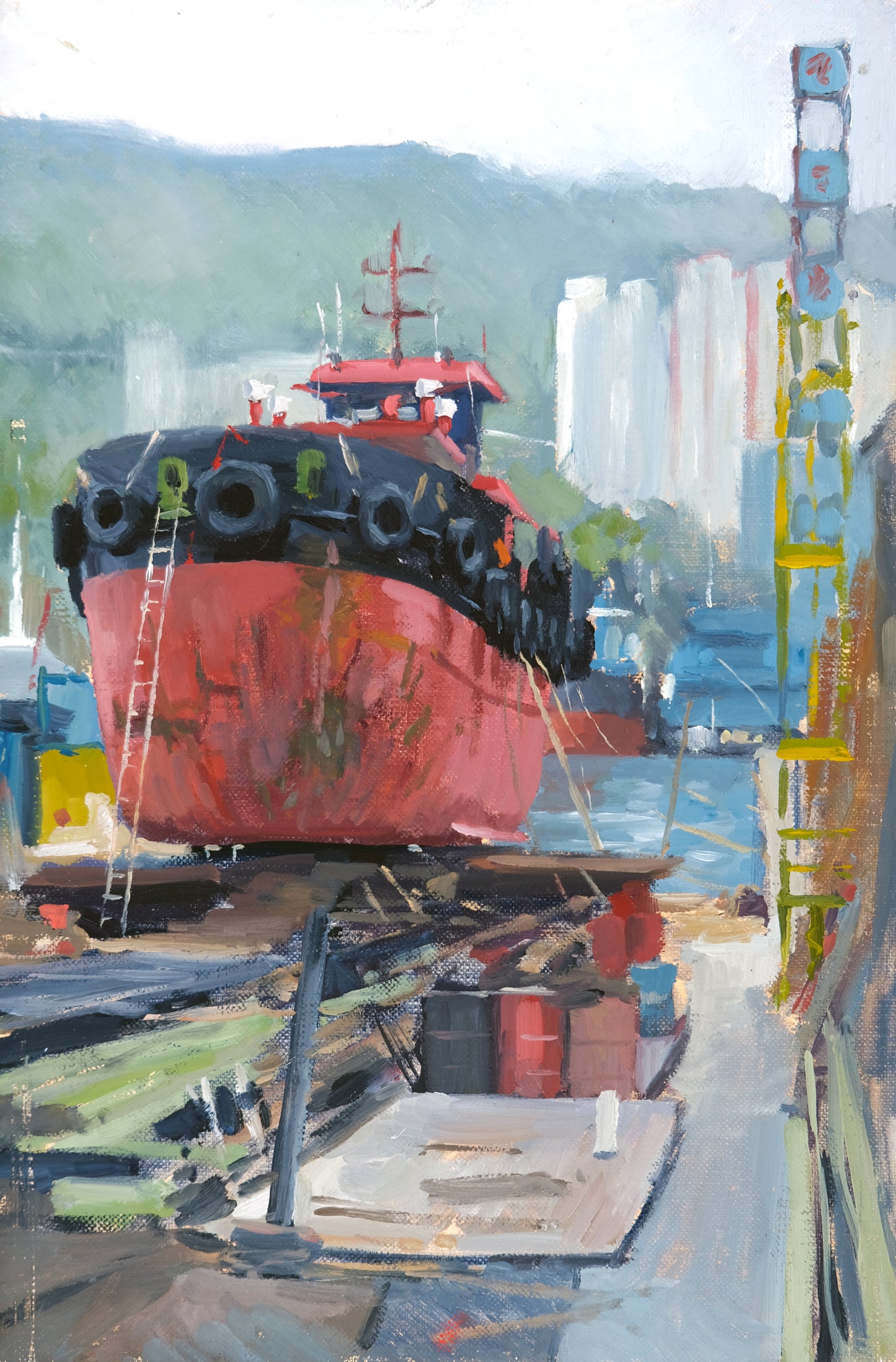 Red ship in dry dock with urban skyline in the background