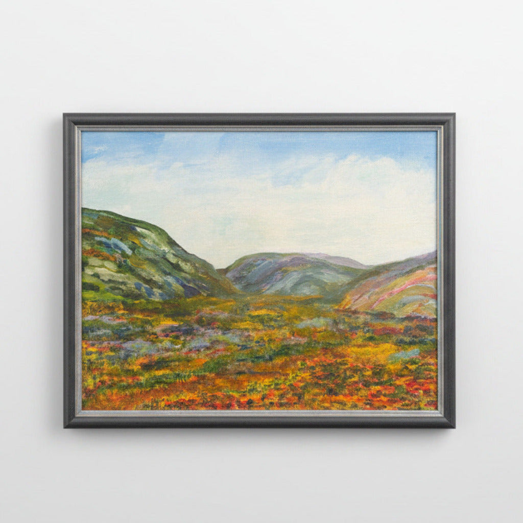 Framed landscape painting with colorful scenery on a white surface