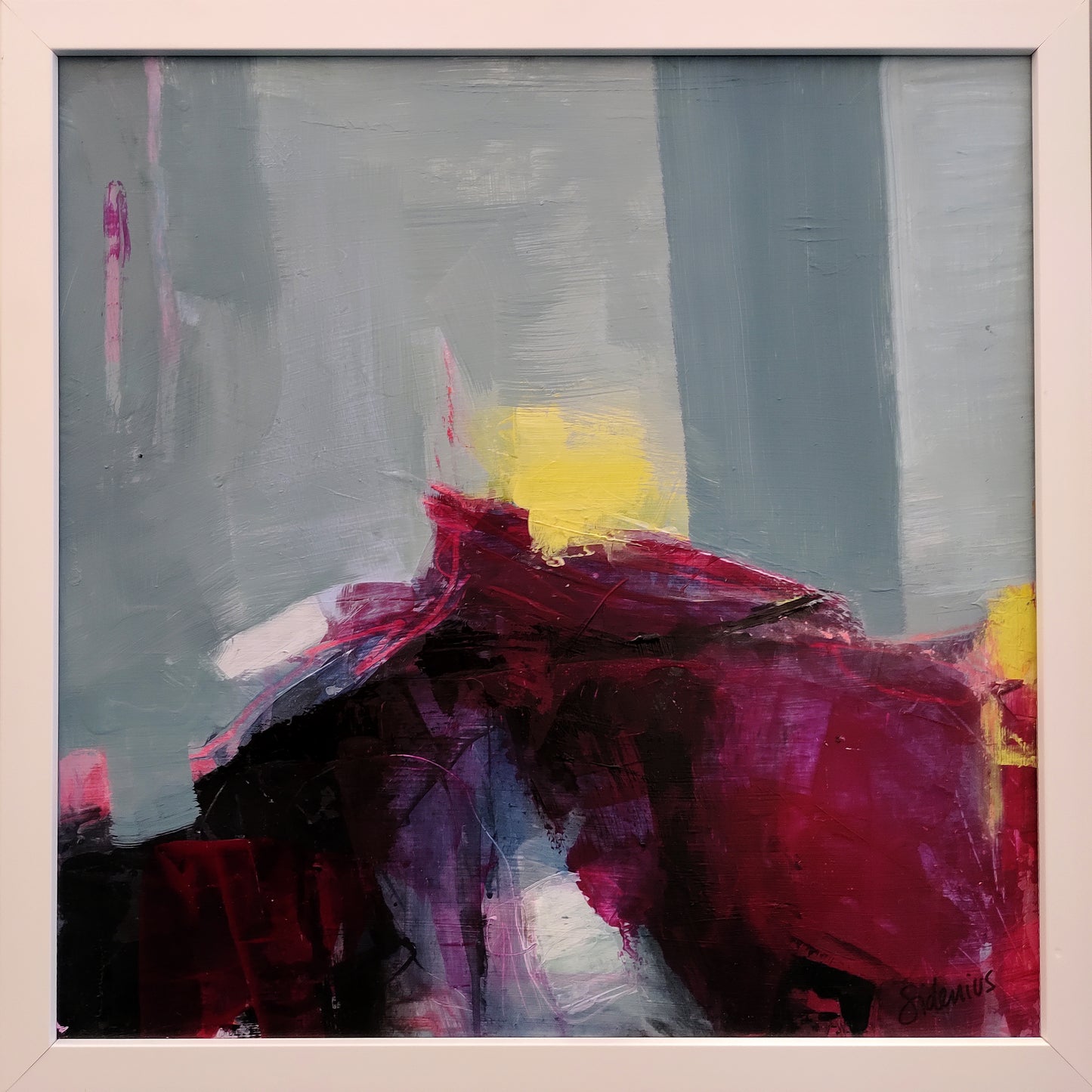 Abstract painting of Arthur's Seat in Edinburgh with red, yellow, and gray colors in a white frame.