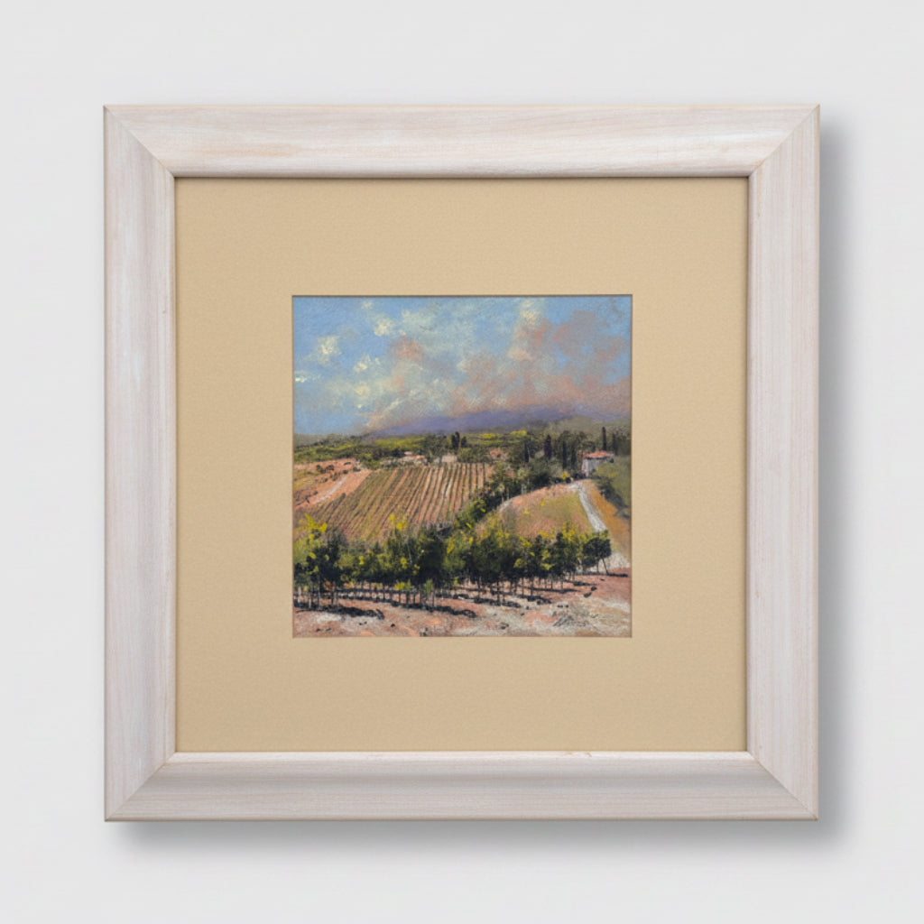 Framed painting of a landscape with trees and mountains on a textured wall.