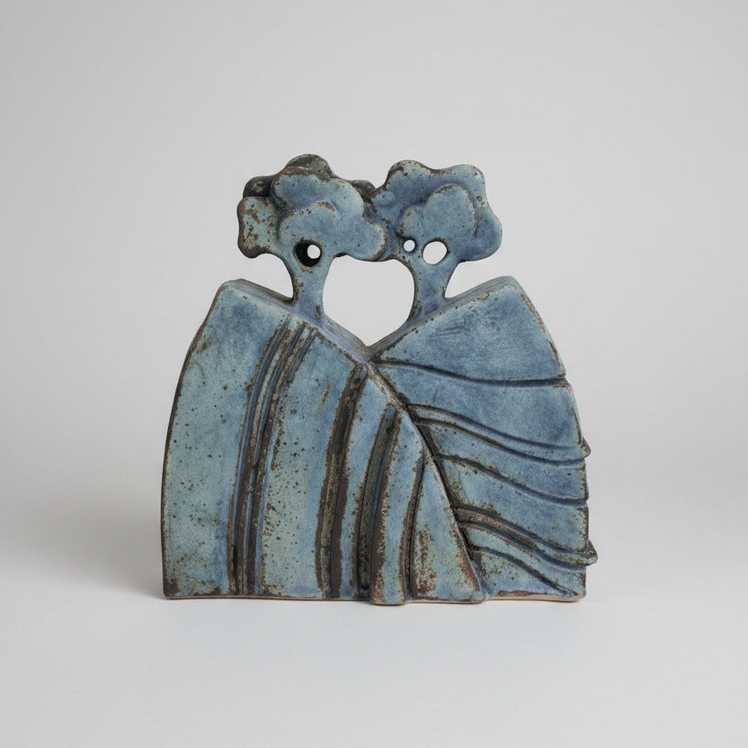 Decorative ceramic piece with tree design on a textured wall