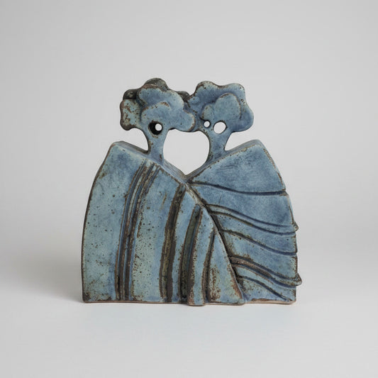 Decorative ceramic piece with tree design on a textured wall