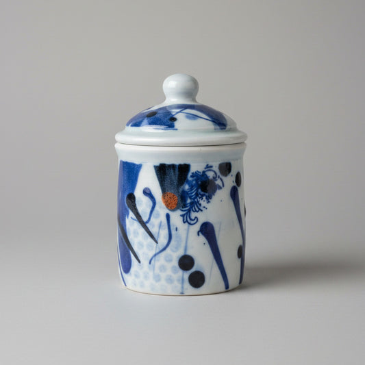 Ceramic jar with blue and white floral design on a textured white background