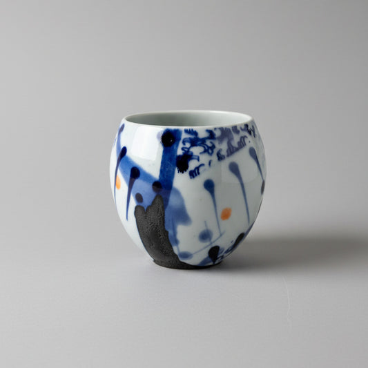 Ceramic bowl with blue and white abstract design on a white wall