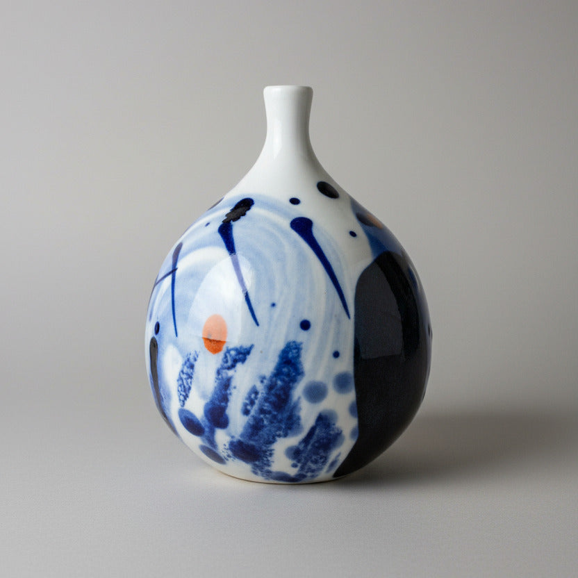 Ceramic vase with blue and white abstract design on a textured white background