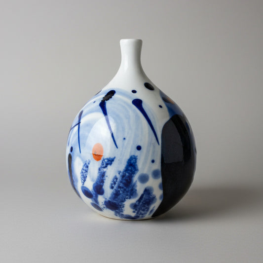 Ceramic vase with blue and white abstract design on a textured white background