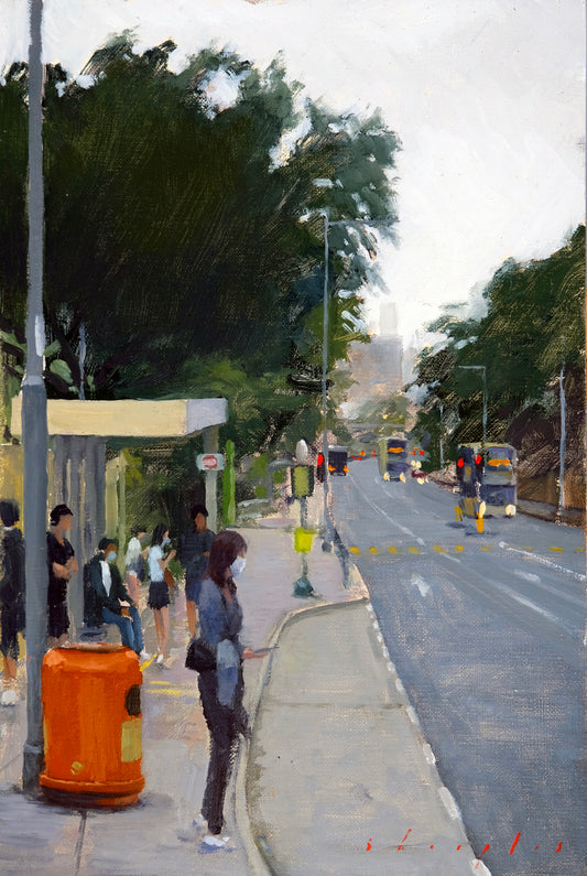 Street scene with people at a bus stop and vehicles on a road.