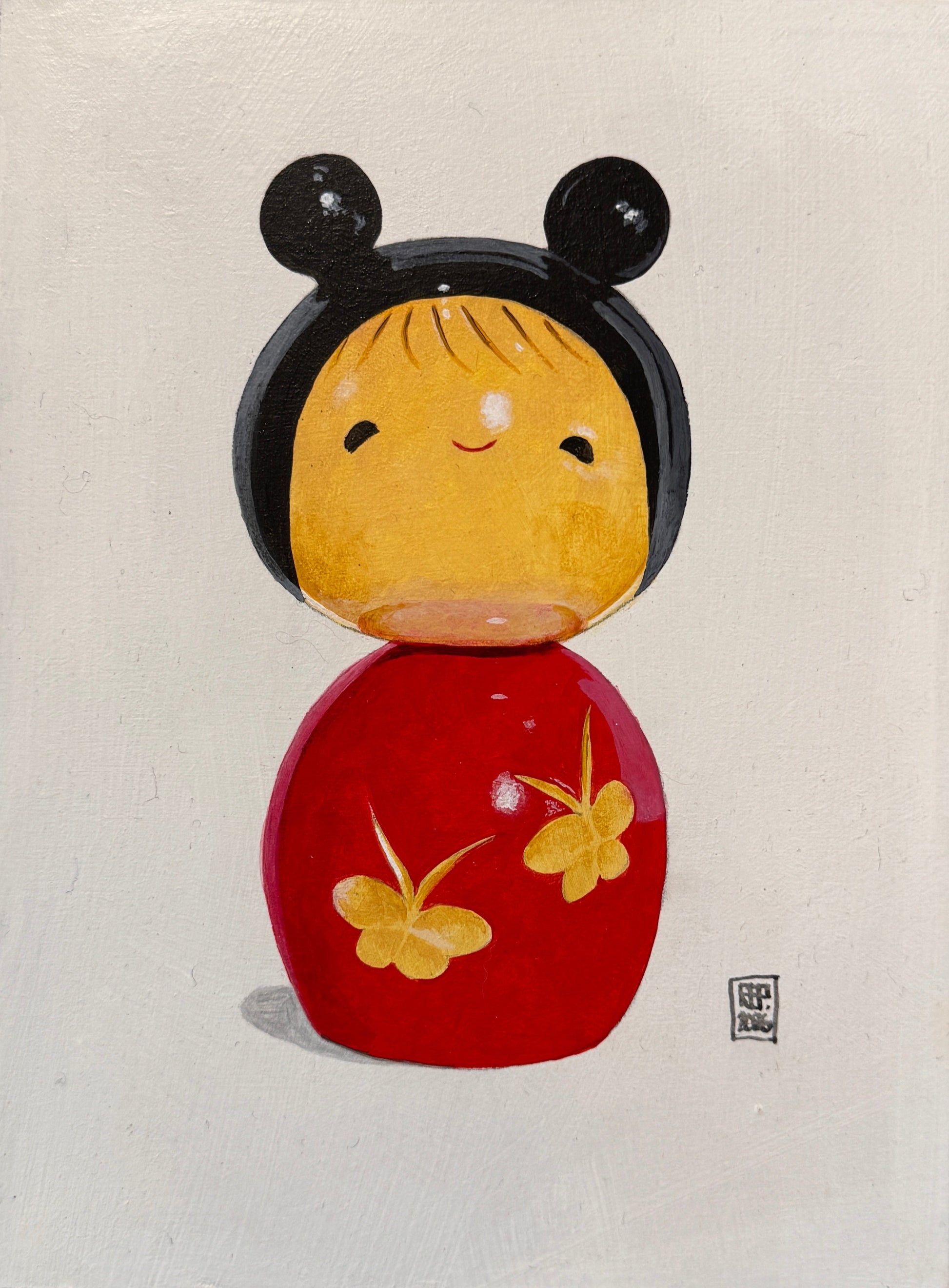 Framed artwork of a stylized face with black, yellow, and red elements on a textured wall.