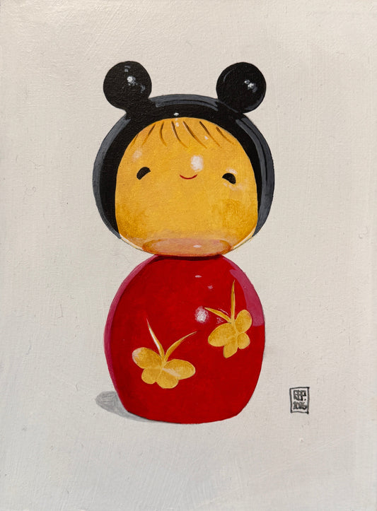 Framed artwork of a stylized face with black, yellow, and red elements on a textured wall.