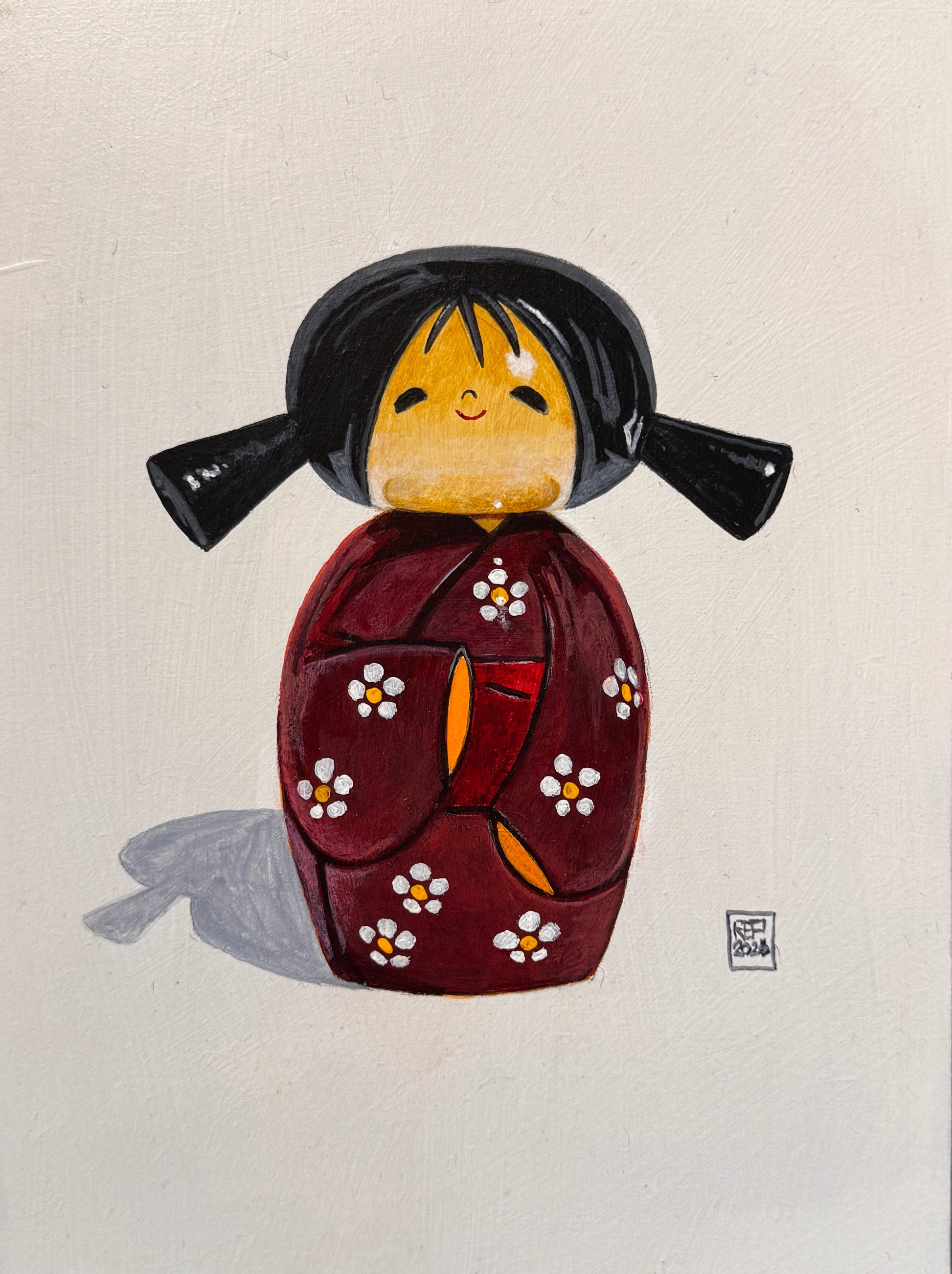 Framed artwork of a traditional Japanese mask on a textured wall background