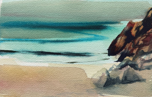 Watercolor painting of a beach scene with turquoise ocean waves, pale sand, and dark rocky formations on the right side.
