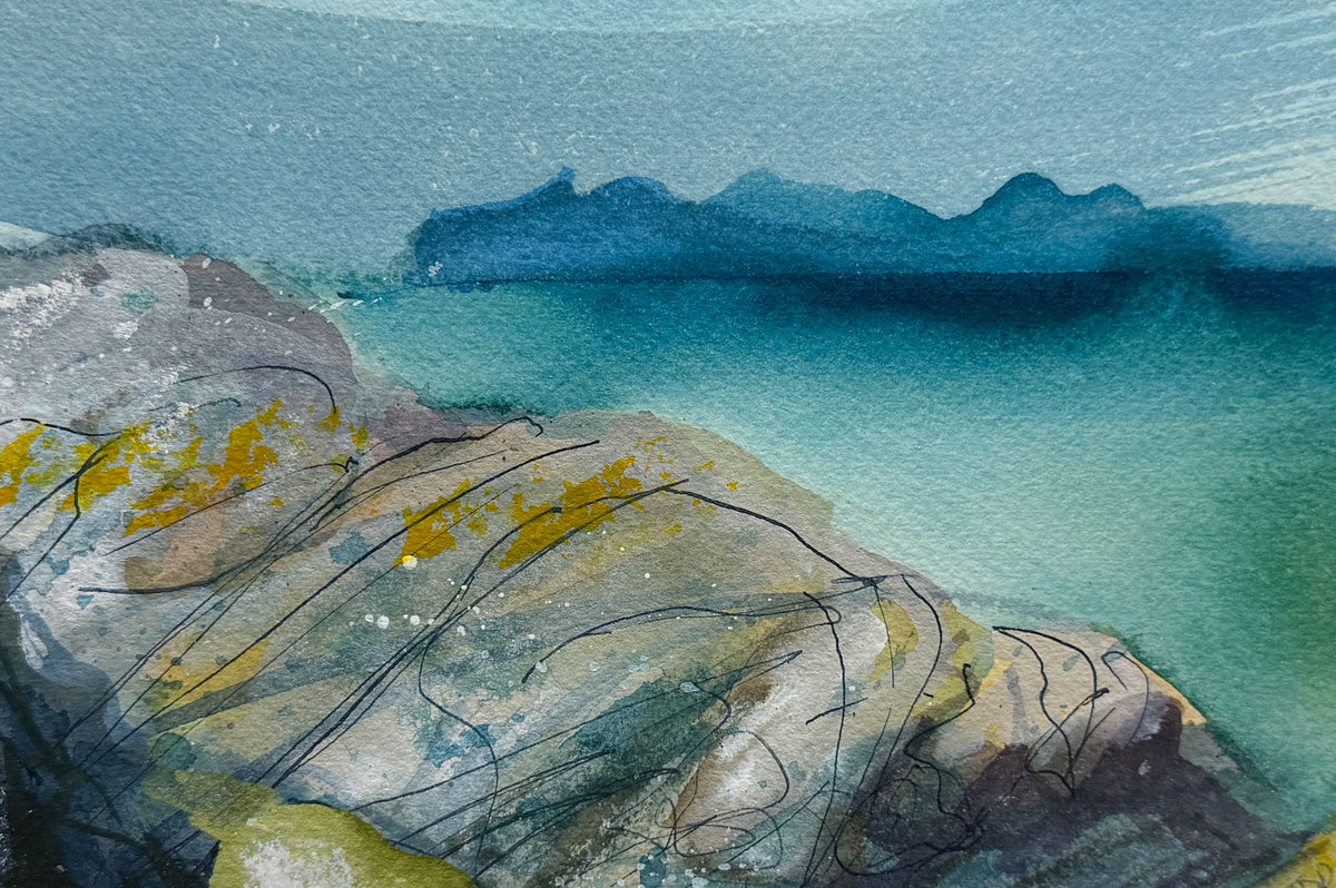 Abstract watercolor and ink landscape artwork showing rocky foreground in gray, blue, and yellow-green tones, meeting a teal sea and distant blue mountain silhouette.