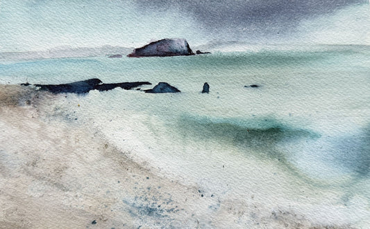 Watercolor painting of a calm sea scene with pale blue-green water, a sandy shore in the foreground, dark rocks, and a cloudy gray sky.