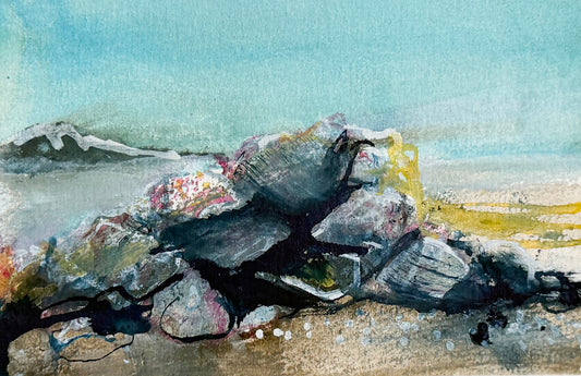 Watercolor landscape painting depicting a pile of dark gray rocks in the foreground with a soft blue sky and distant hills.