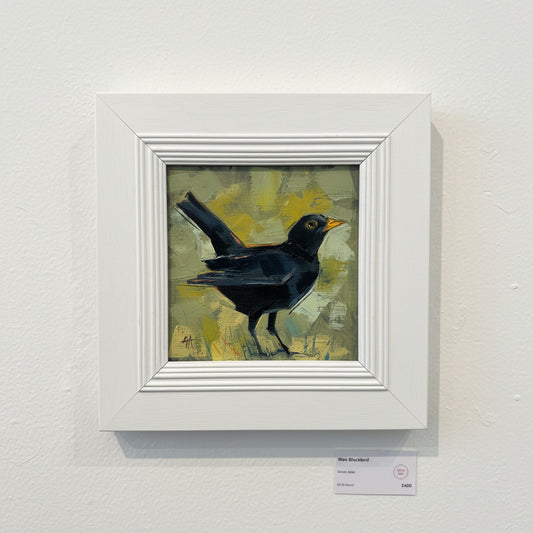 Framed painting of a black bird on a textured wall