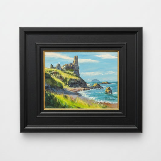 Framed painting of coastal landscape with cliffs and ocean.