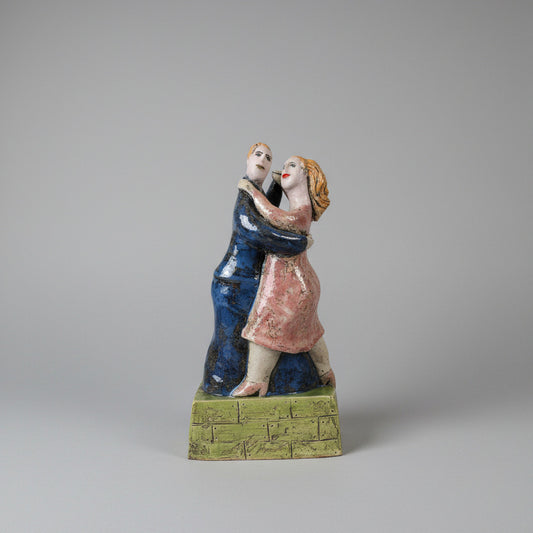  ceramic figurine of a couple on a white surface