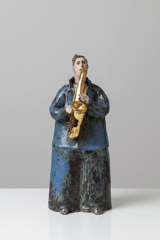 figurine of a person holding a saxophone against a plain background