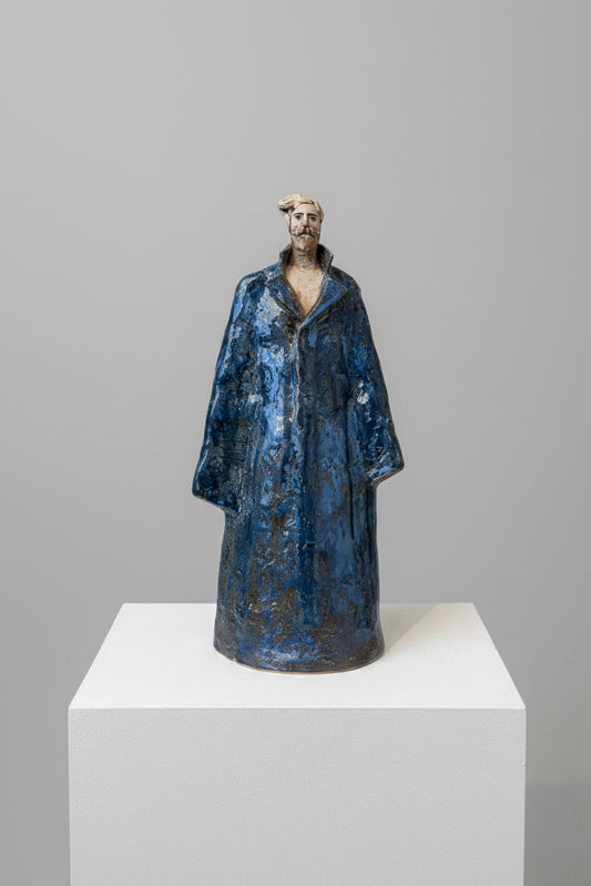 Statue of a person in a blue robe on a white surface