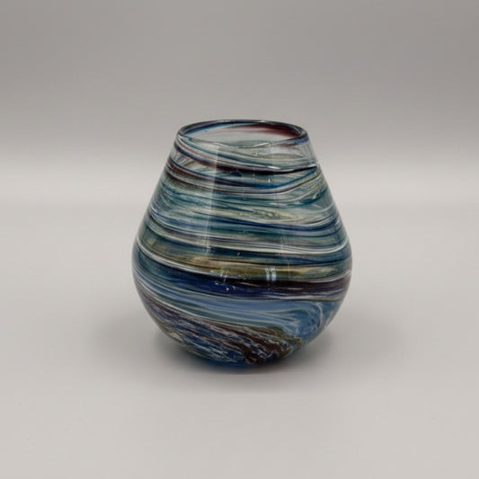 Multicolored glass vase on a textured white surface
