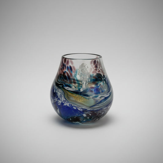 Handmade glass vase with multicolored design on a white background