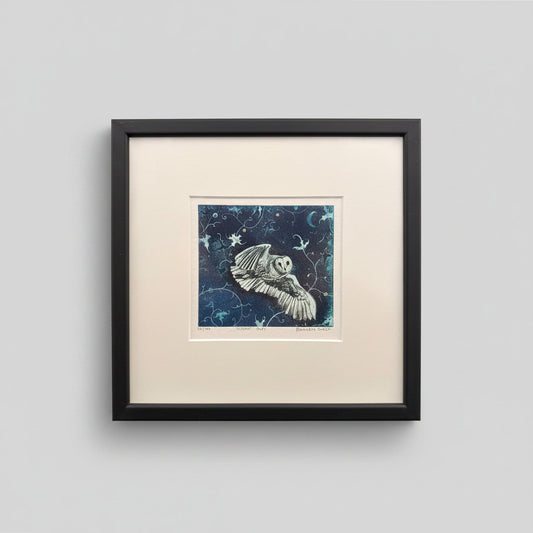 Framed artwork of an owl with a starry night background on a light gray wall.