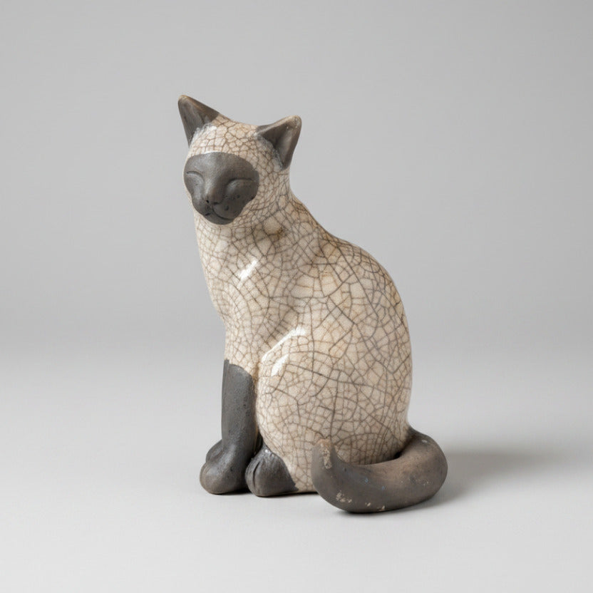 Ceramic cat figurine with a cracked glaze finish on a white background