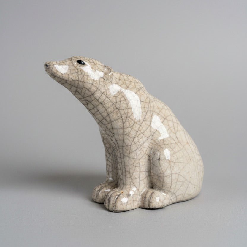 Ceramic polar bear sculpture on a textured white surface