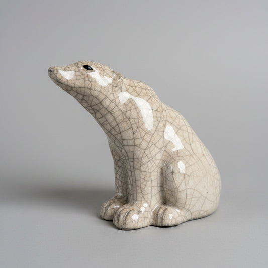 Ceramic polar bear sculpture on a textured white surface