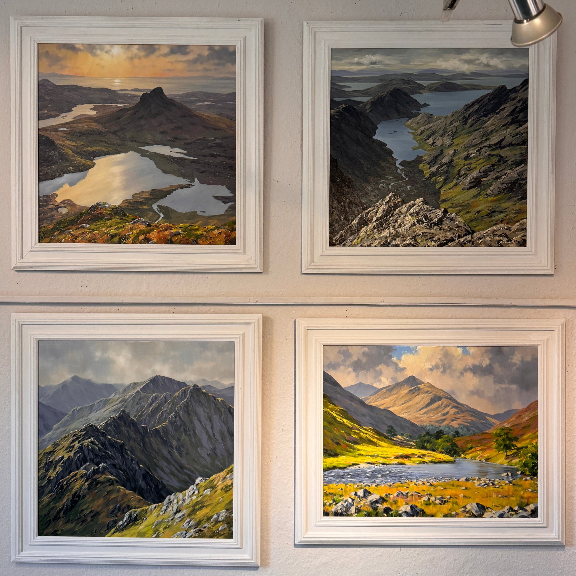 Four framed landscape photographs on a wall