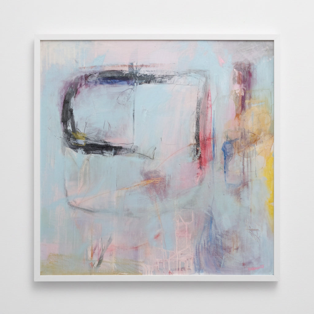 Framed abstract artwork with colorful shapes on a white wall