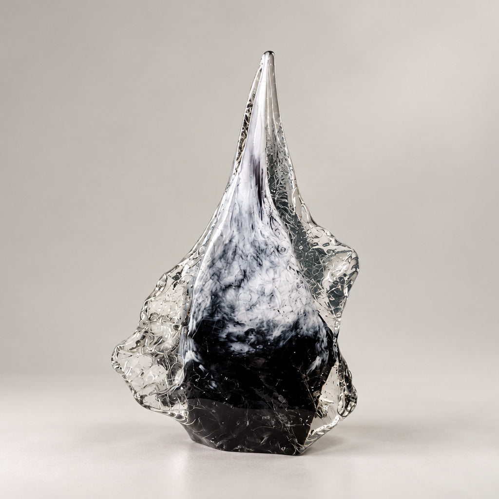 A sculptural, ice-like crystal formation with a pointed top and jagged edges, resting on a white display pedestal in an art gallery or museum setting.