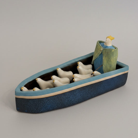 Decorative wall shelf with ceramic geese on a plain wall