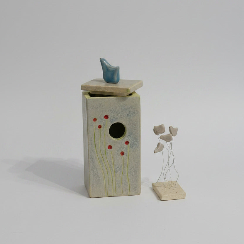 Ceramic birdhouse with abstract design on a white background