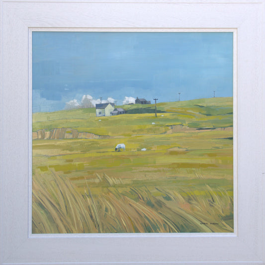 Framed artwork of a landscape with green fields and houses under a blue sky.
