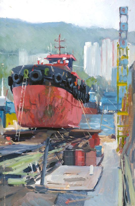Red ship in dry dock with urban skyline in the background