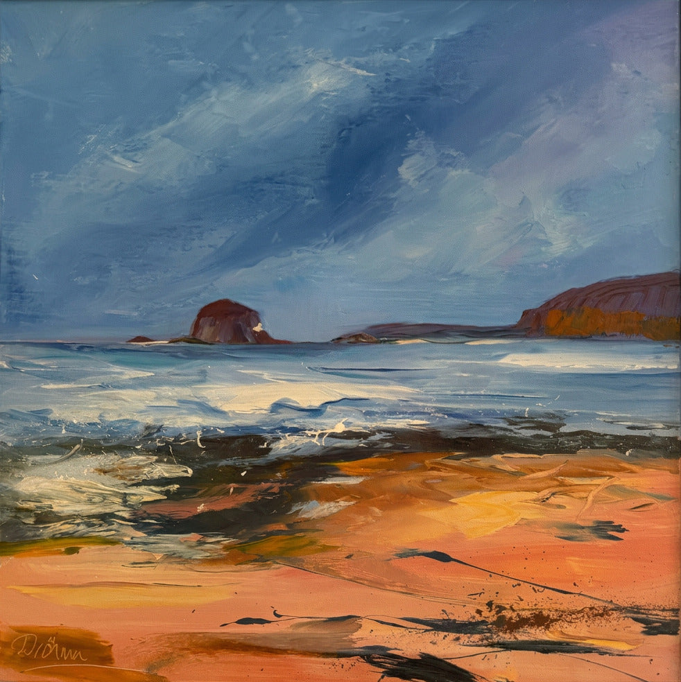 A framed landscape painting featuring a beach scene with blue sky, water, and warm orange-brown sand, housed in a light wood frame. A faint reflection of a person is visible on the glass.