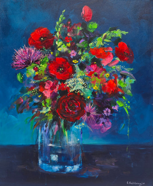Colorful bouquet of flowers in a clear vase against a dark blue background