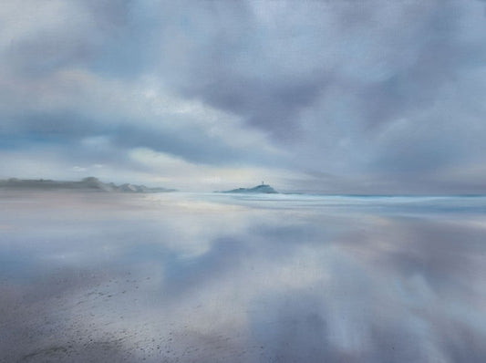 Reflective water surface with cloud reflections on a beach