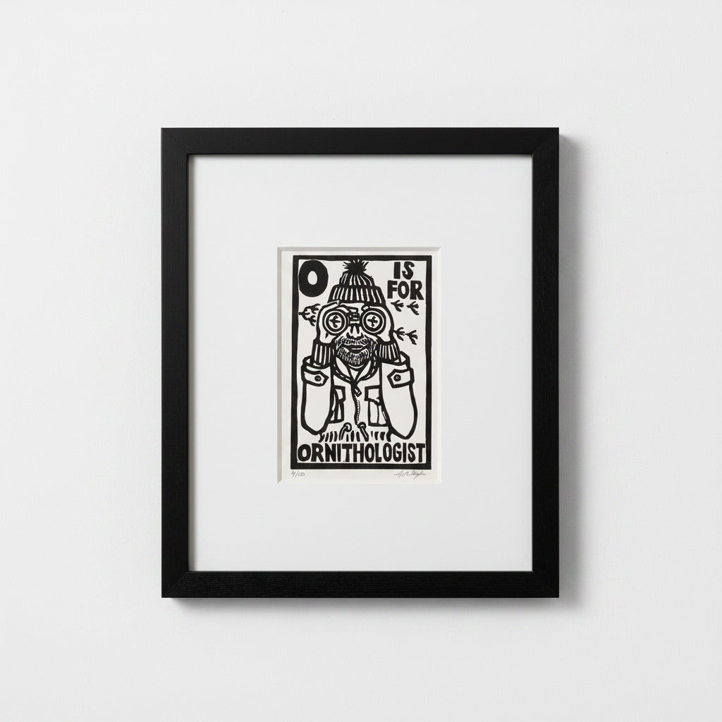 A framed black and white art print featuring a whimsical illustration of a bird wearing binoculars and the text 'O IS FOR ORNITHOLOGIST', displayed in a black frame against a light gray wall.