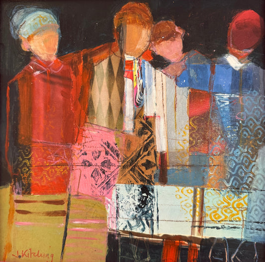 A framed abstract painting featuring four stylized figures in warm and cool tones, enclosed in a bright pink frame. The artwork is photographed resting on a desk with papers visible around it.