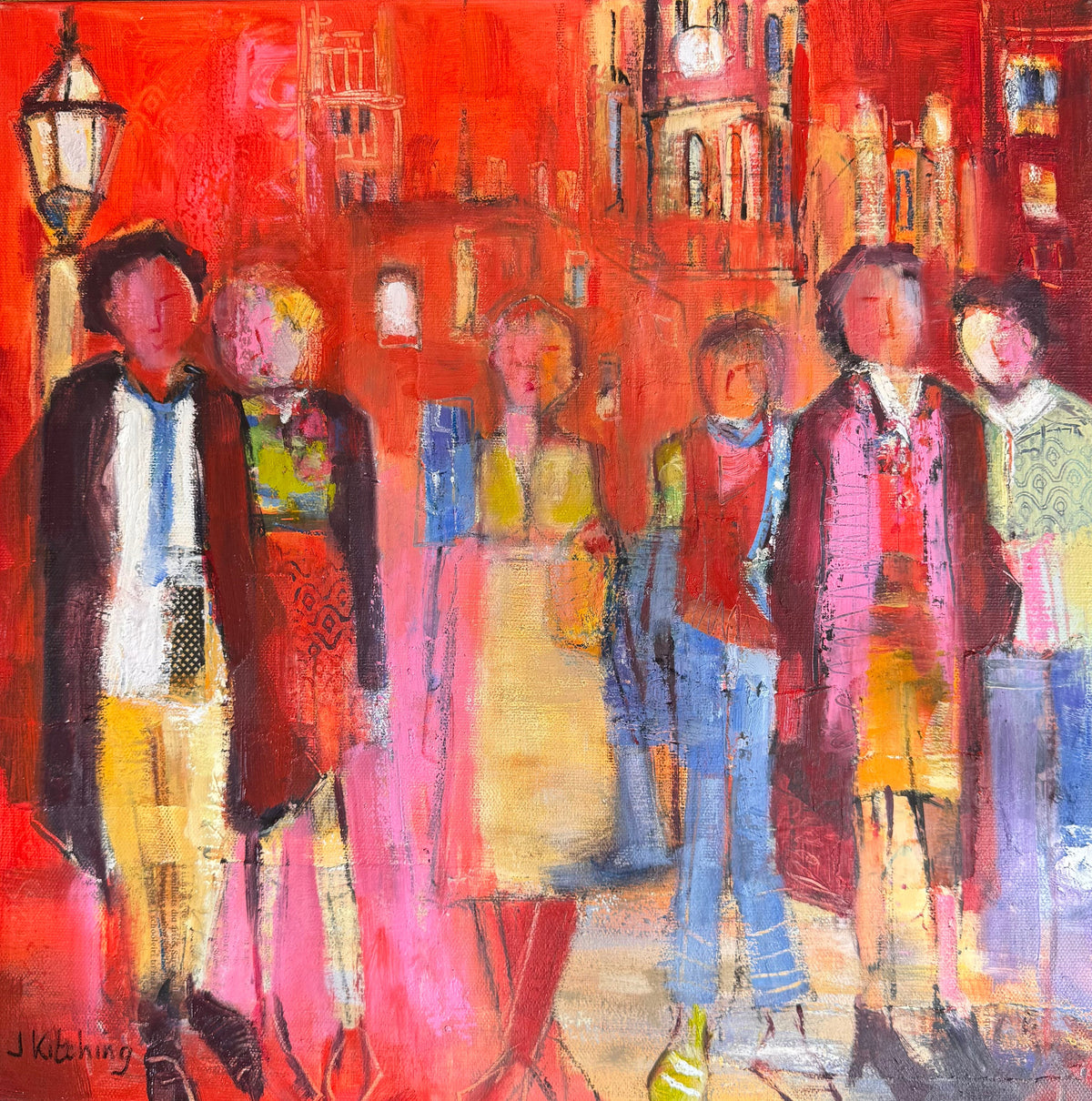 An expressive, colorful painting of five people standing in a city street scene, rendered in bold reds, pinks, yellows, blues, and browns. The artwork fills nearly the entire frame, with a small portion of a tan paper corner visible at the top left and the painting resting on a dark green textured surface.